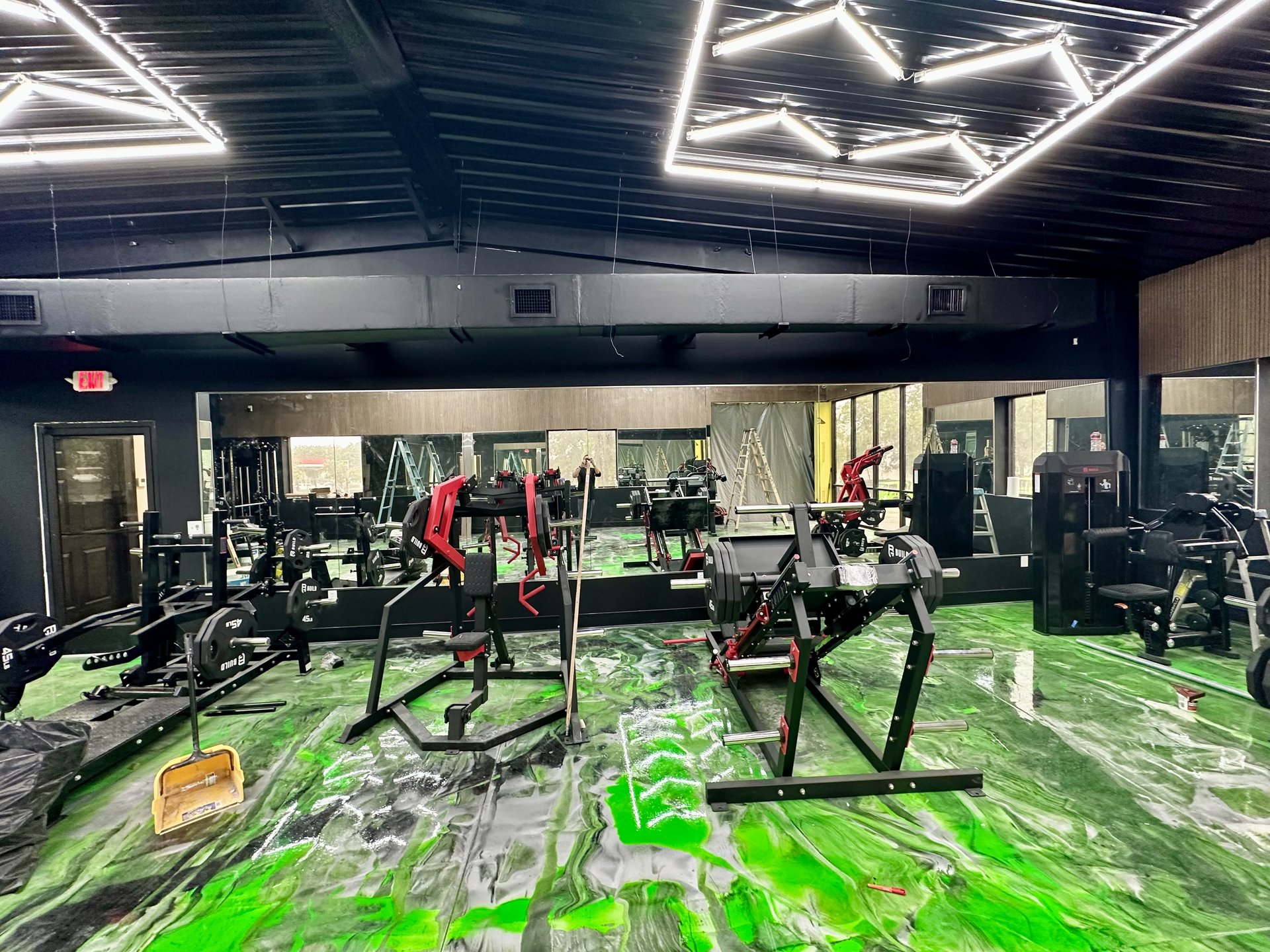 Custom-cut gym mirror wall installed behind weight equipment by BGM Jacksonville