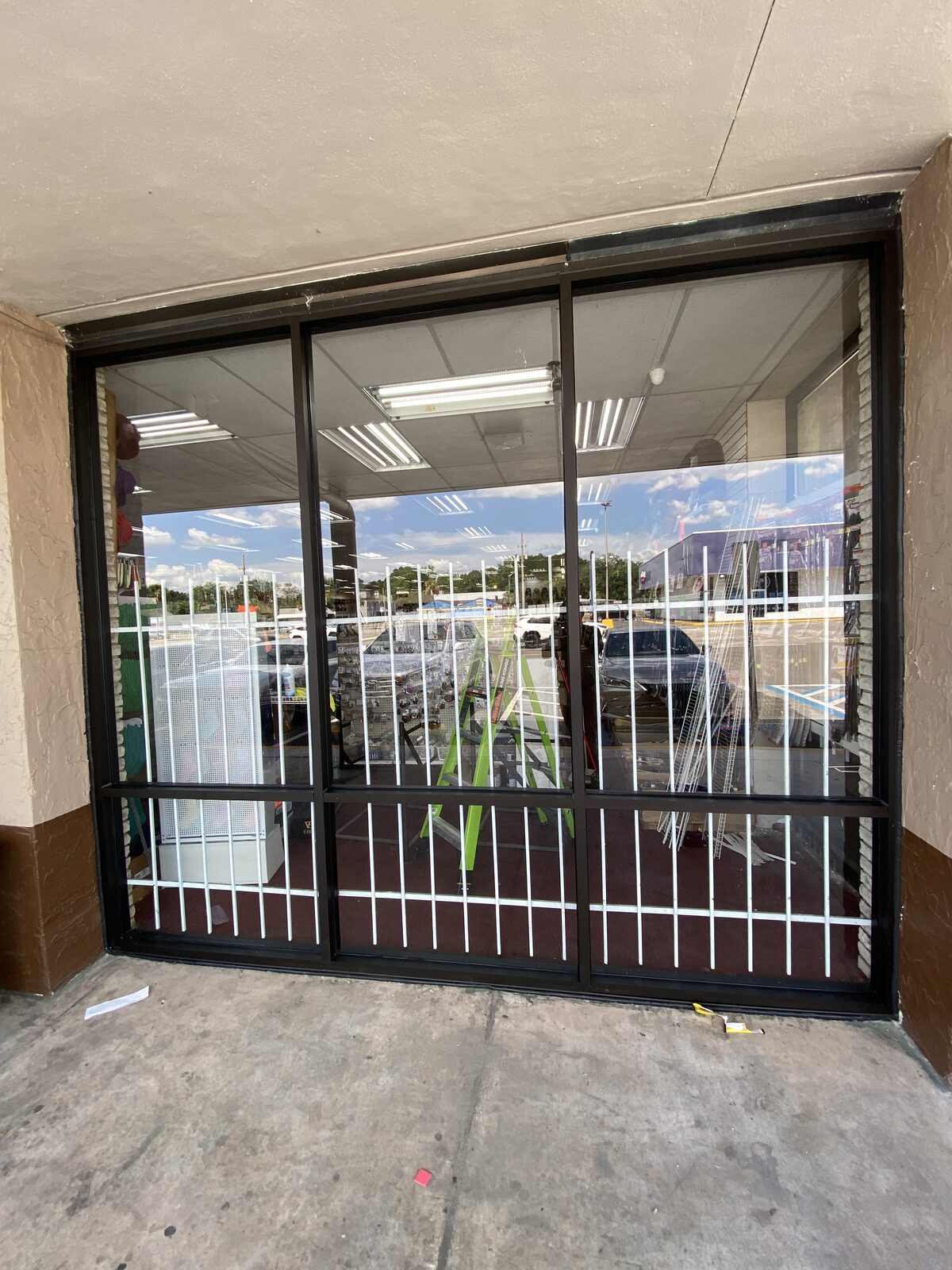 Completed commercial storefront glass installation with security grille by BGM Jacksonville